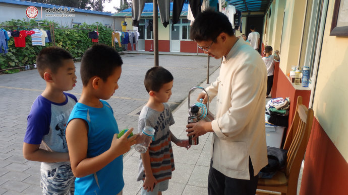 
生活老師為小學(xué)員添水，給予悉心照顧和安全教育