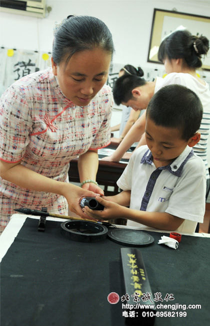 一手托著瓶底，一手扶住瓶頸輕輕倒墨，以免濺到外面。