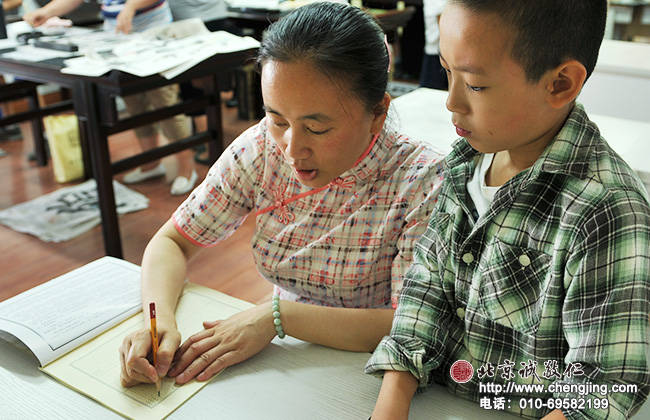 老師給新生講解如何使用《硬筆書法基礎描紅》，它是學習書法最好的輔助教材。