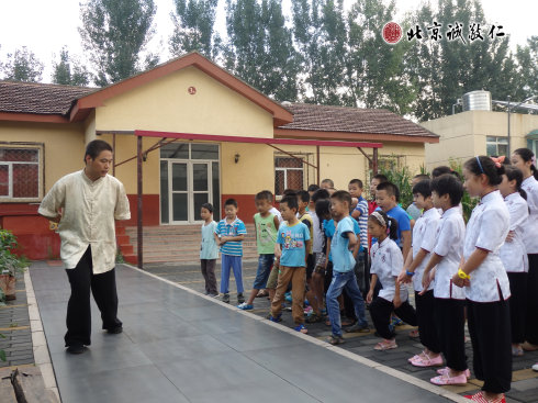 太極拳教練認真指導小學員步步禪動作要領