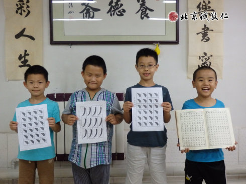 書法二班的小學員展示定心描紅習作