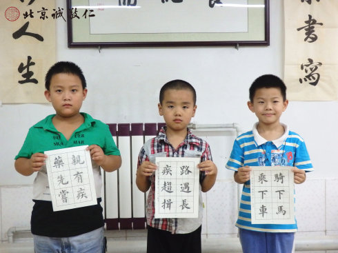 書法二班的小學員展示定心描紅習作