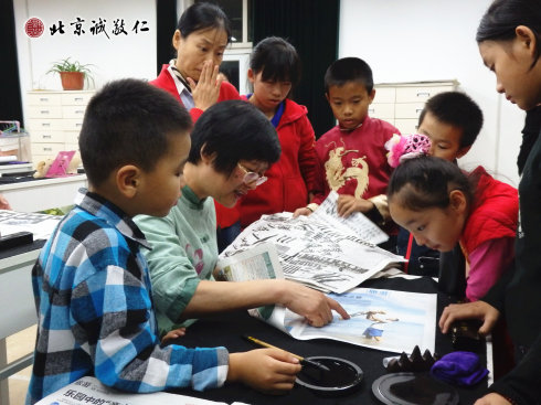 配圖：楊老師指導(dǎo)小學(xué)員書(shū)法要領(lǐng) 彩色較多的報(bào)紙不宜用來(lái)書(shū)寫(xiě)