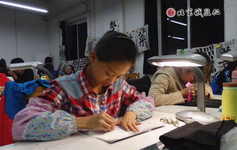 配圖：篆刻班里學(xué)員專(zhuān)注的習(xí)練篆刻，